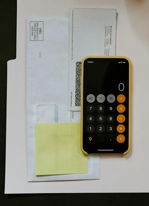 Phone calculator and paperwork on a desk