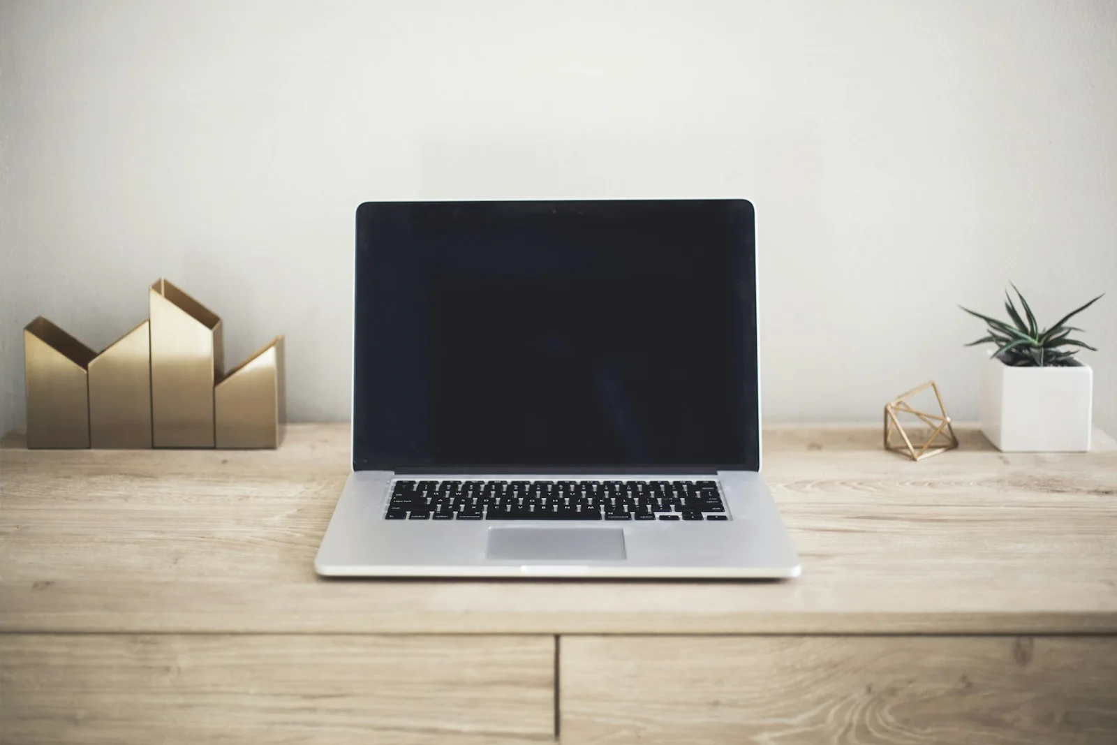 Laptop on a desk beside a window